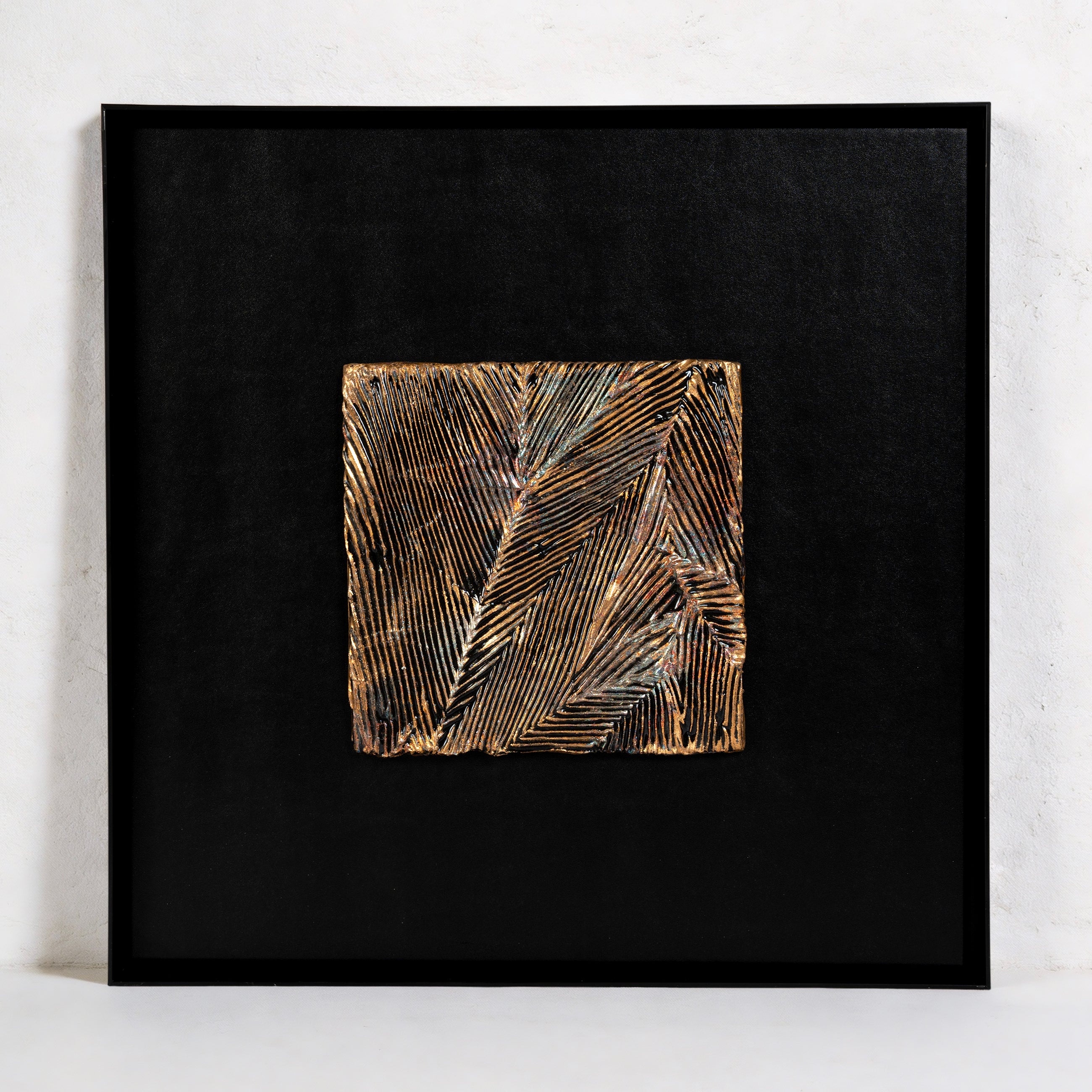 Striae — Patinated Foil · Aura Frame, full view of a metal element wall art where AetherCanvas® mineral pigment builds a directional crackle terrain, ICH-certified fired foil running in parallel striations across the fractured surface like a vein of ore moving with purpose through rock.
