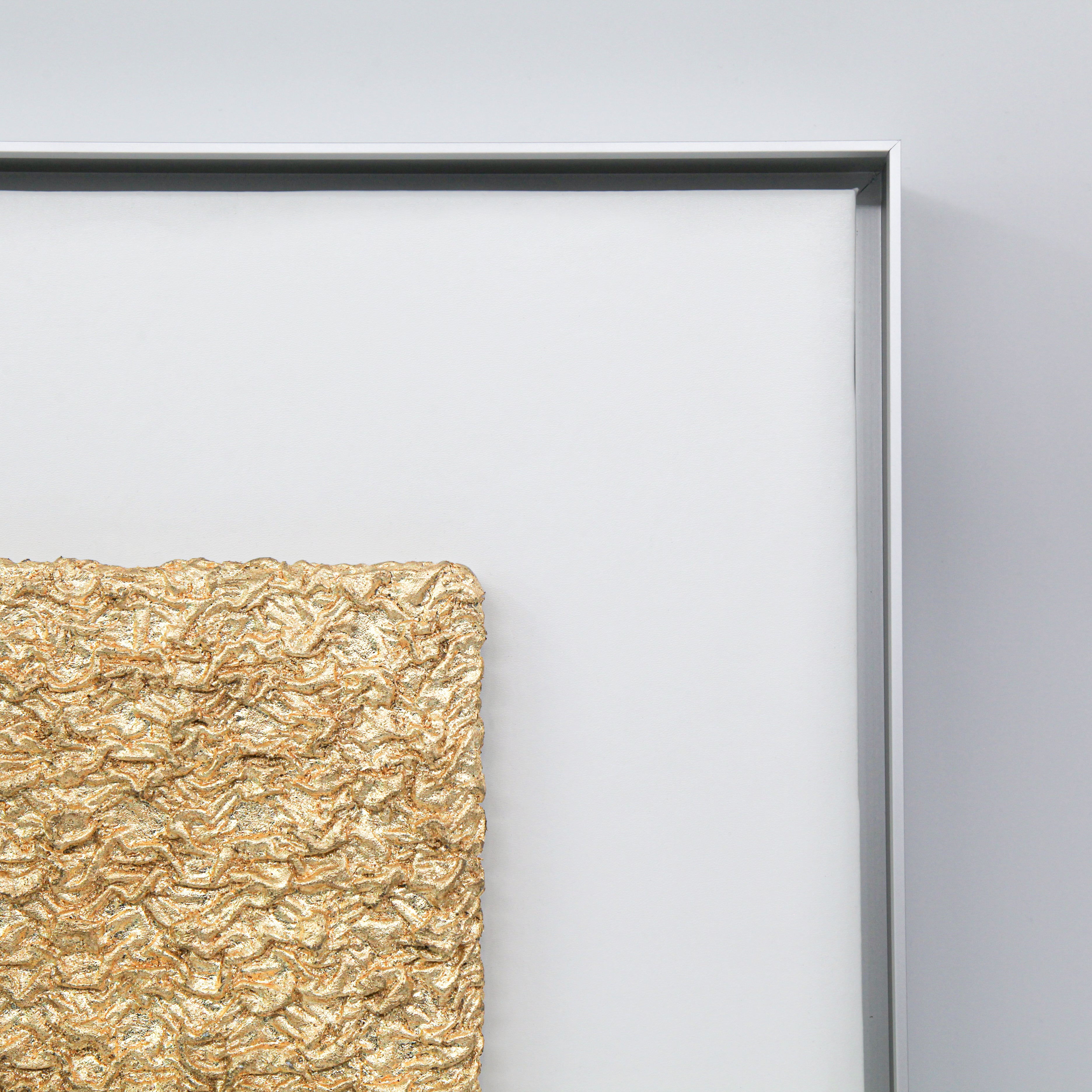 Corner detail of Shan — Gilded Foil · Aura Frame, showing the hand-folded earth element mineral ridges and fissures where 0.1-micron gilded foil settles into the terrain — not applied but present, surfacing from within the 3D textured ground like ore from soil.